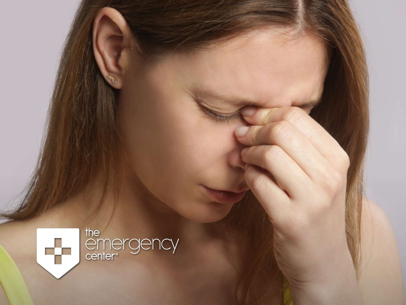 Woman pinching the bridge of her nose with her eyes closed from sinus infection pain and pressure